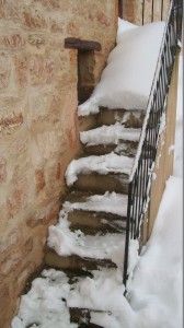 La scalinata di una casa disabitata usata ai fini “televisivi”. Nel servizio infatti è ripreso in primo piano un agente della Forestale che rimuove la neve con la pala